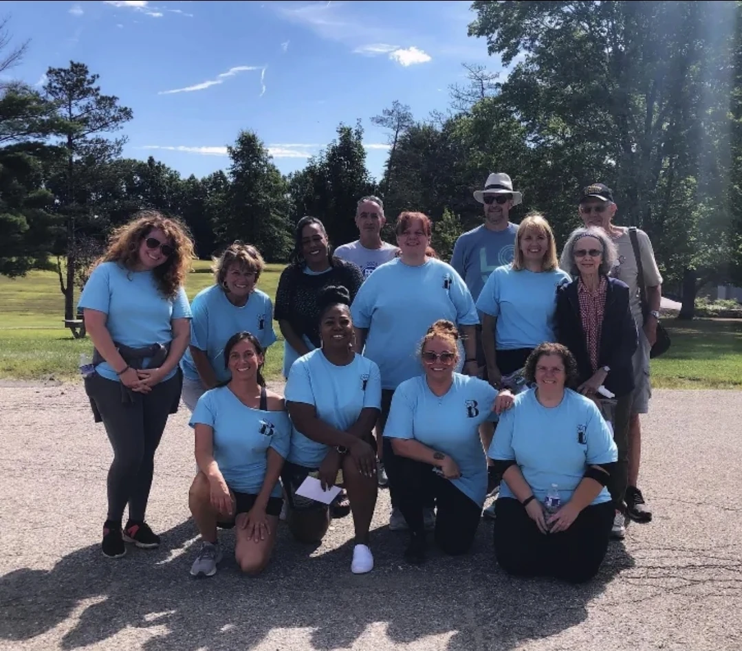 Back To The Garden Cleaning team and community members outdoors in matching light blue shirts